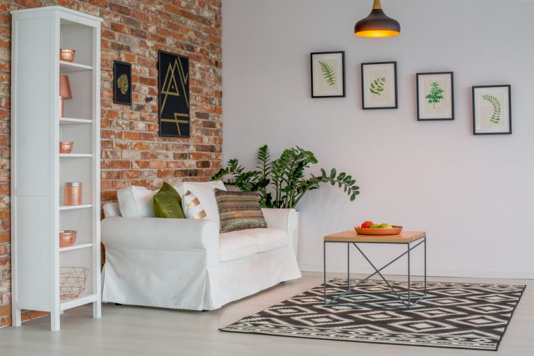 soggiorno con divano bianco e parete in mattoni