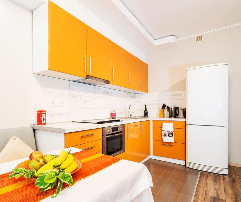 cucina in arancio con tavolo e frutta