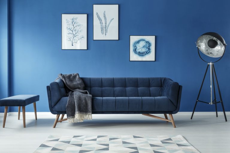 soggiorno con quadri su parete blu