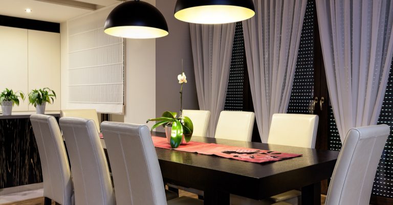 sala da pranzo con sedie bianche e tavolo nero