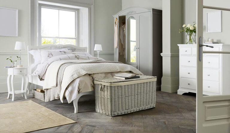 baule vicino al letto in vimini bianco