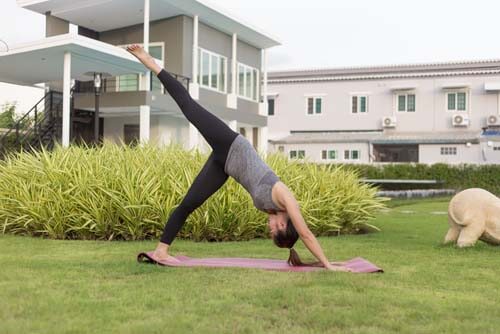 Ragazza fa yoga in giardino
