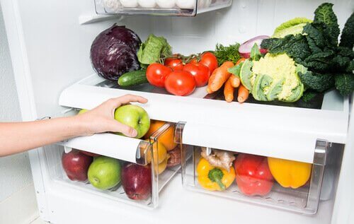 Mano prende mela dal frigo