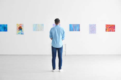 Visitatore guarda dipinti in un museo