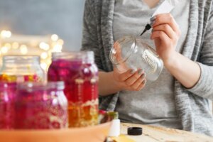 Ragazza dipinge barattoli di vetro