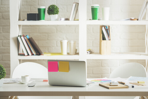 libreria bianca ordinata e tavolo con computer