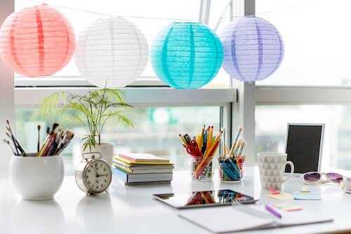 Tavolo vicino alla finestra con matite penne sveglia quaderno