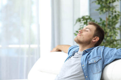Uomo che si rilassa seduto sul divano