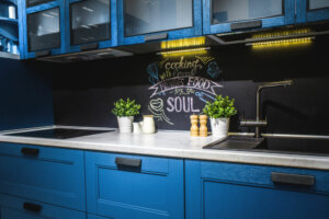 Cucina in legno blu con scritta sulla parete