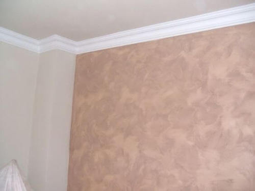 Parete con pittura decorativa effetto spugnato.