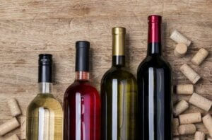 Bottiglie di vino diverso con tappi di sughero sparsi