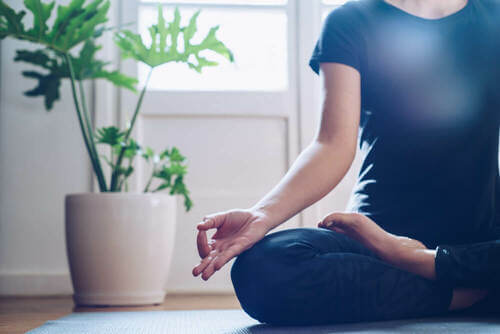 Donna che fa yoga seduta sul pavimento.