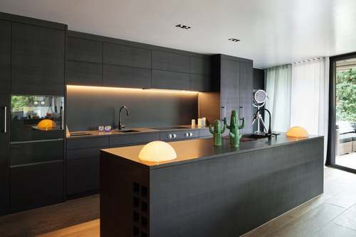 Cucina nera con luce calda.
