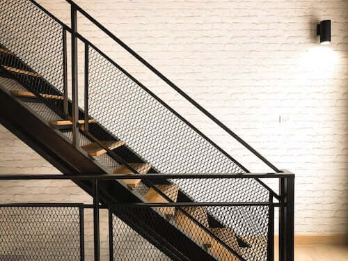 Scala in legno e metallo con una ringhiera per la sicurezza.