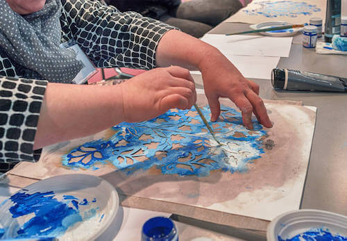 Persona che decora utilizzando la tecnica dello stencil.
