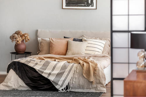 Cuscini dai colori tenui per decorare il letto.